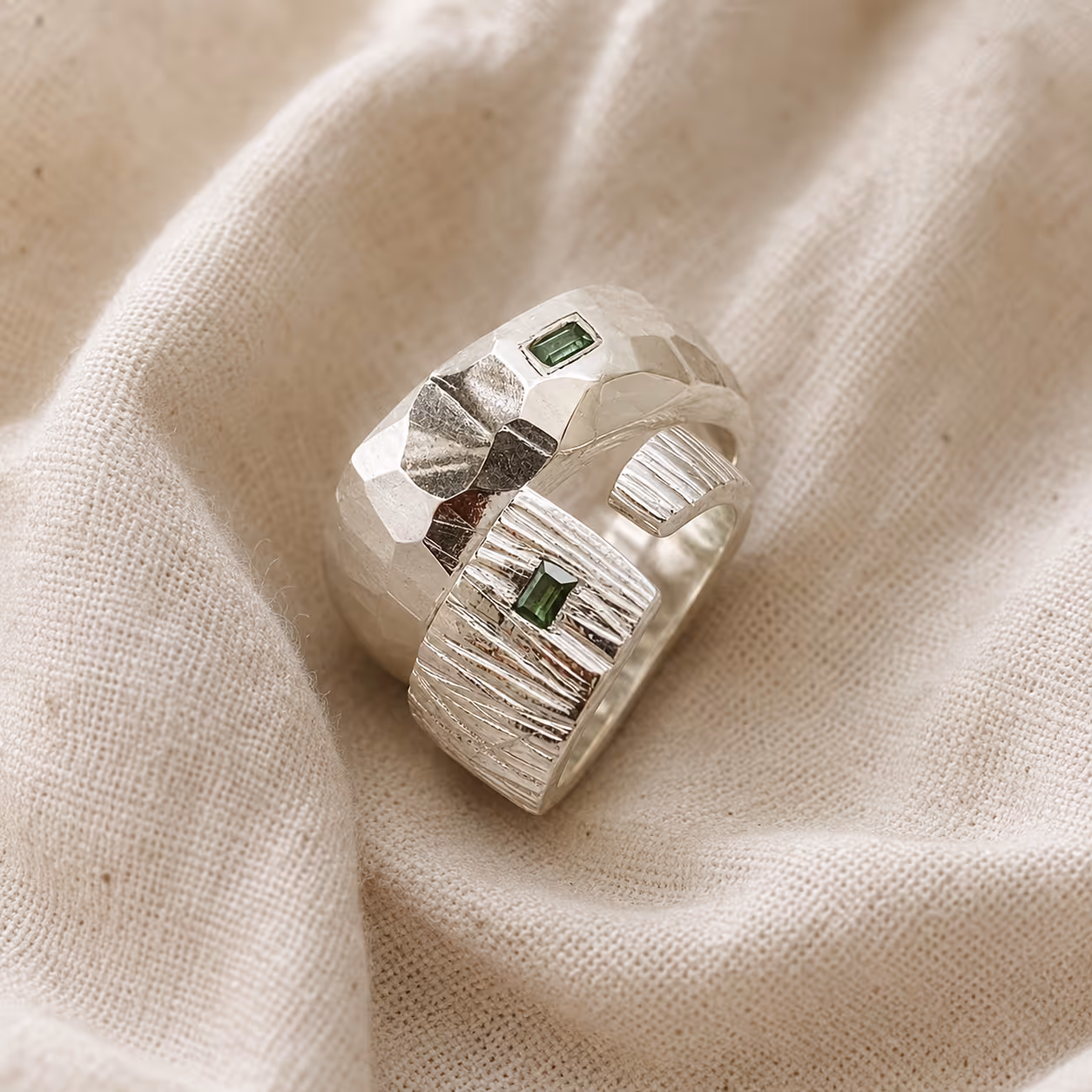 Two silver rings with emerald accents